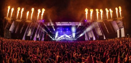 Ein Konzert mit einer großen Menschenmenge und Feuerwerk im Hintergrund.
